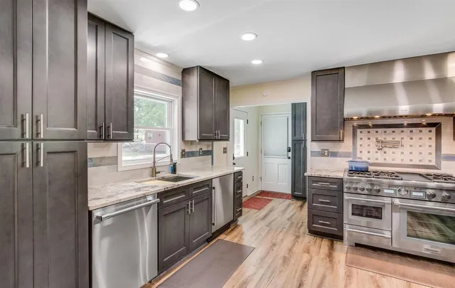 a kitchen with stainless steel appliances granite countertop a stove a sink and a refrigerator