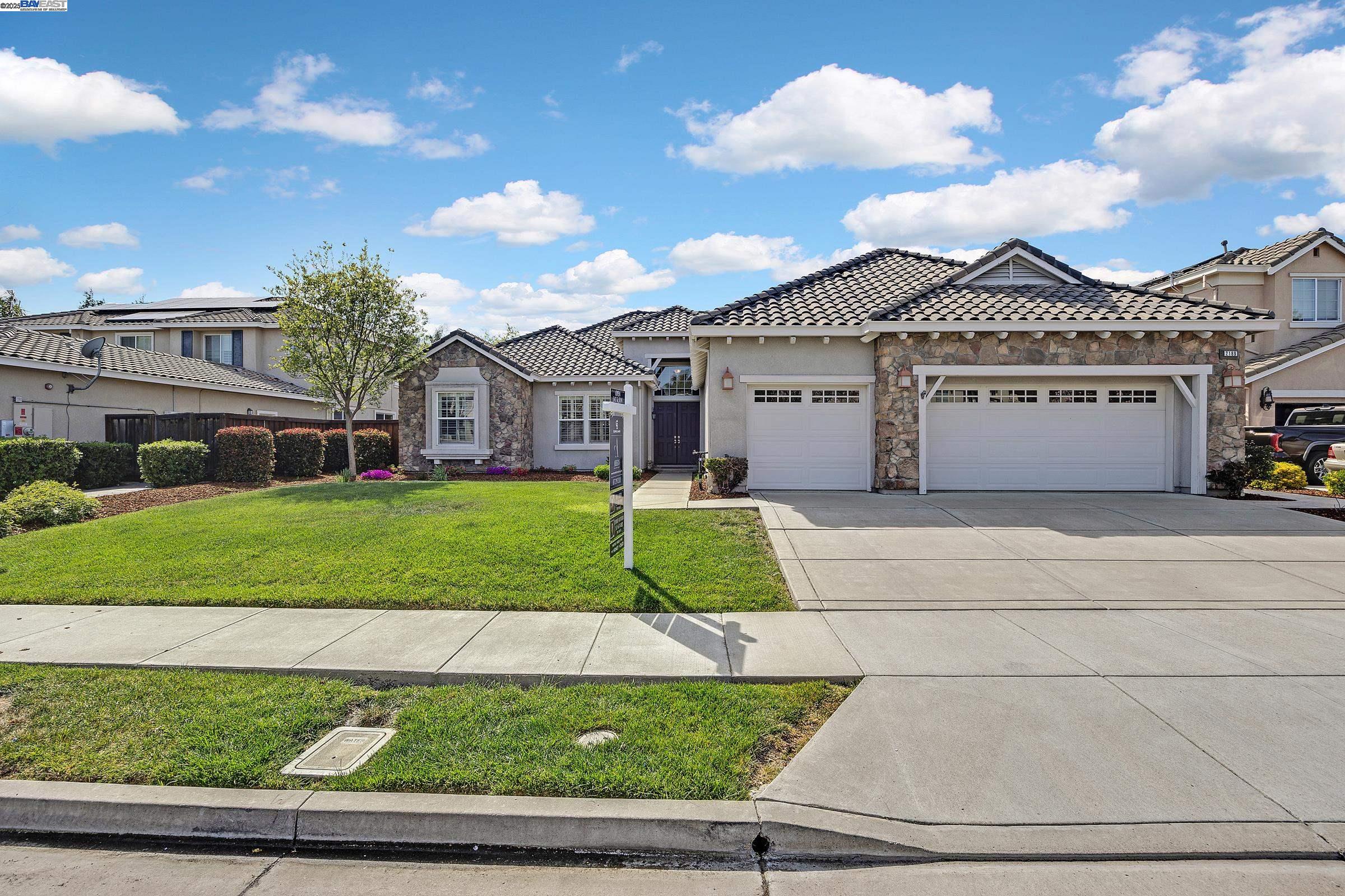 a view of a white house with a big yard and large trees