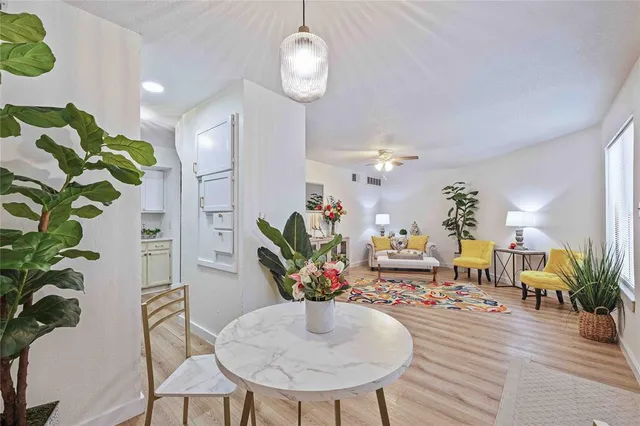 a view of a dining room with furniture a potted plant and wooden floor