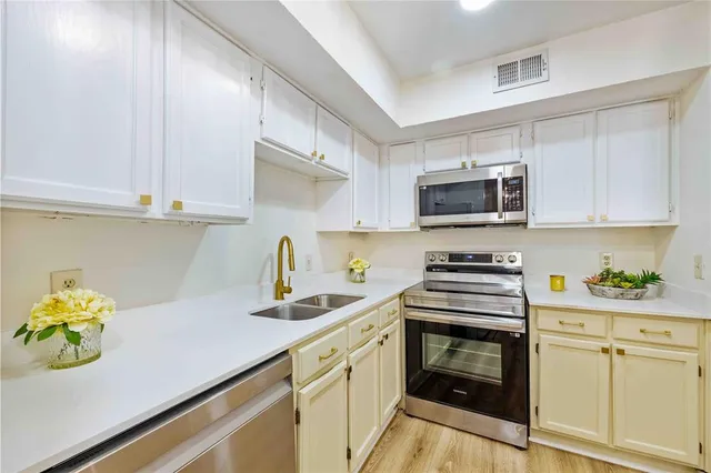 a kitchen with a sink a stove and cabinets