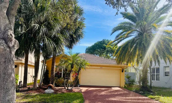 a view of a palm trees front of house