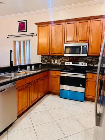 a kitchen with stainless steel appliances a stove a sink and a microwave