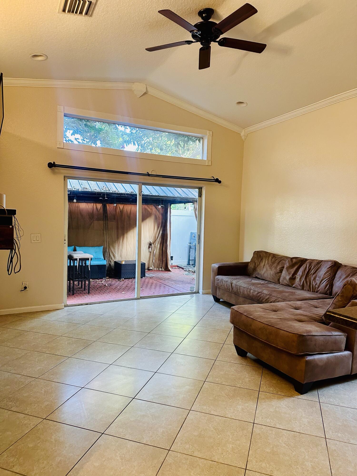 5200 Rising Comet Lane Greenacres, FL 33463 - Photo 16 of 50 a living room with a couch and a floor to ceiling window