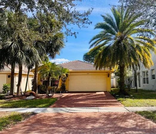 a view of a house with a yard and palm trees