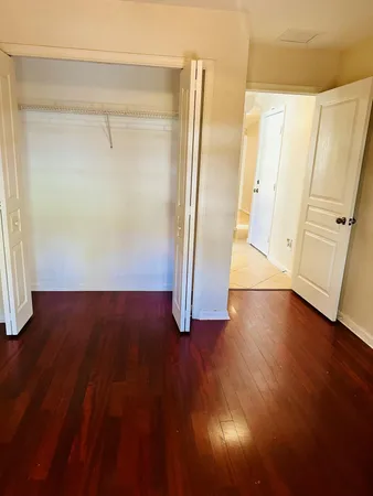 a view of empty room with wooden floor