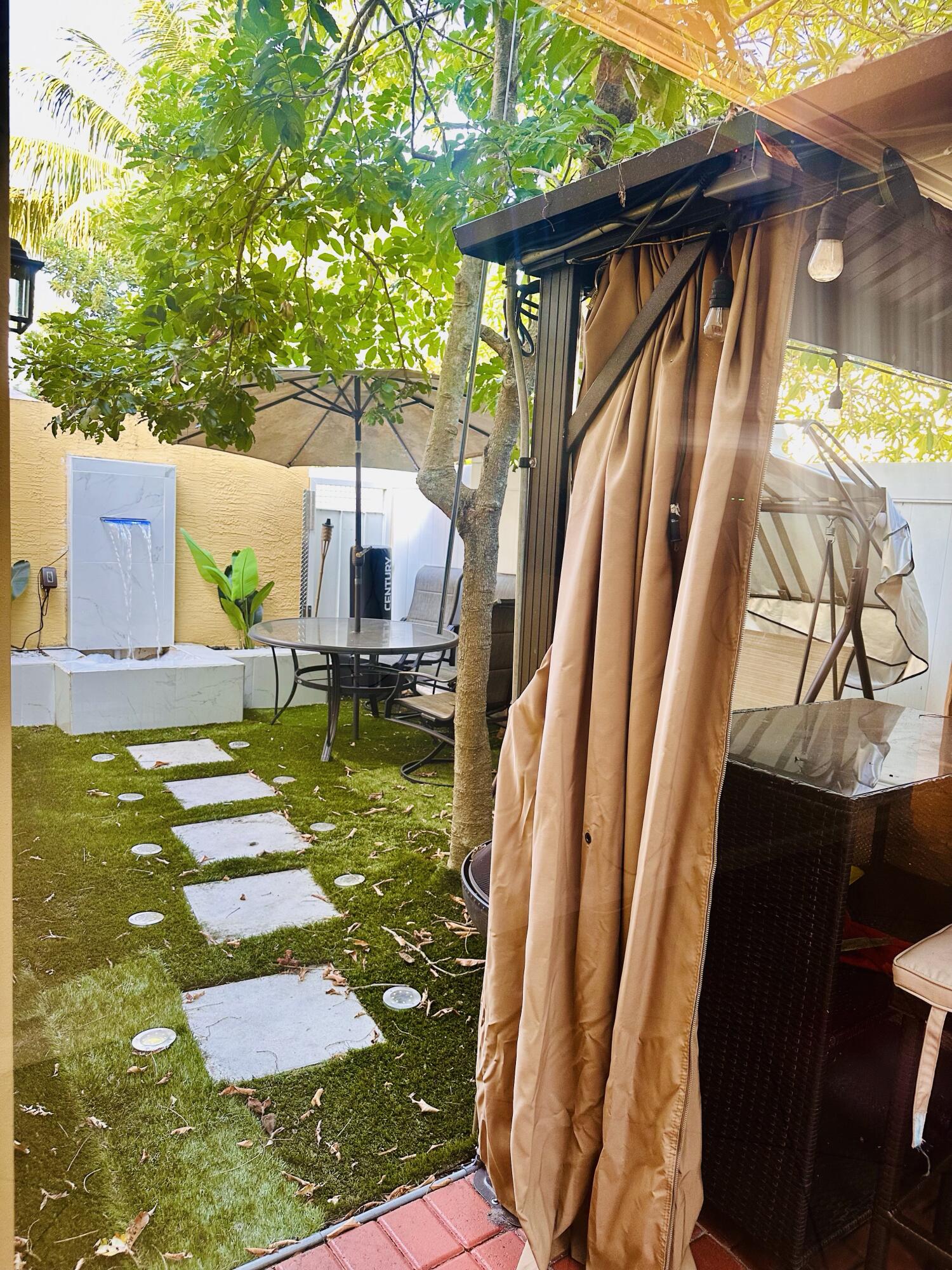 5200 Rising Comet Lane Greenacres, FL 33463 - Photo 35 of 50 a backyard of a house with table and chairs