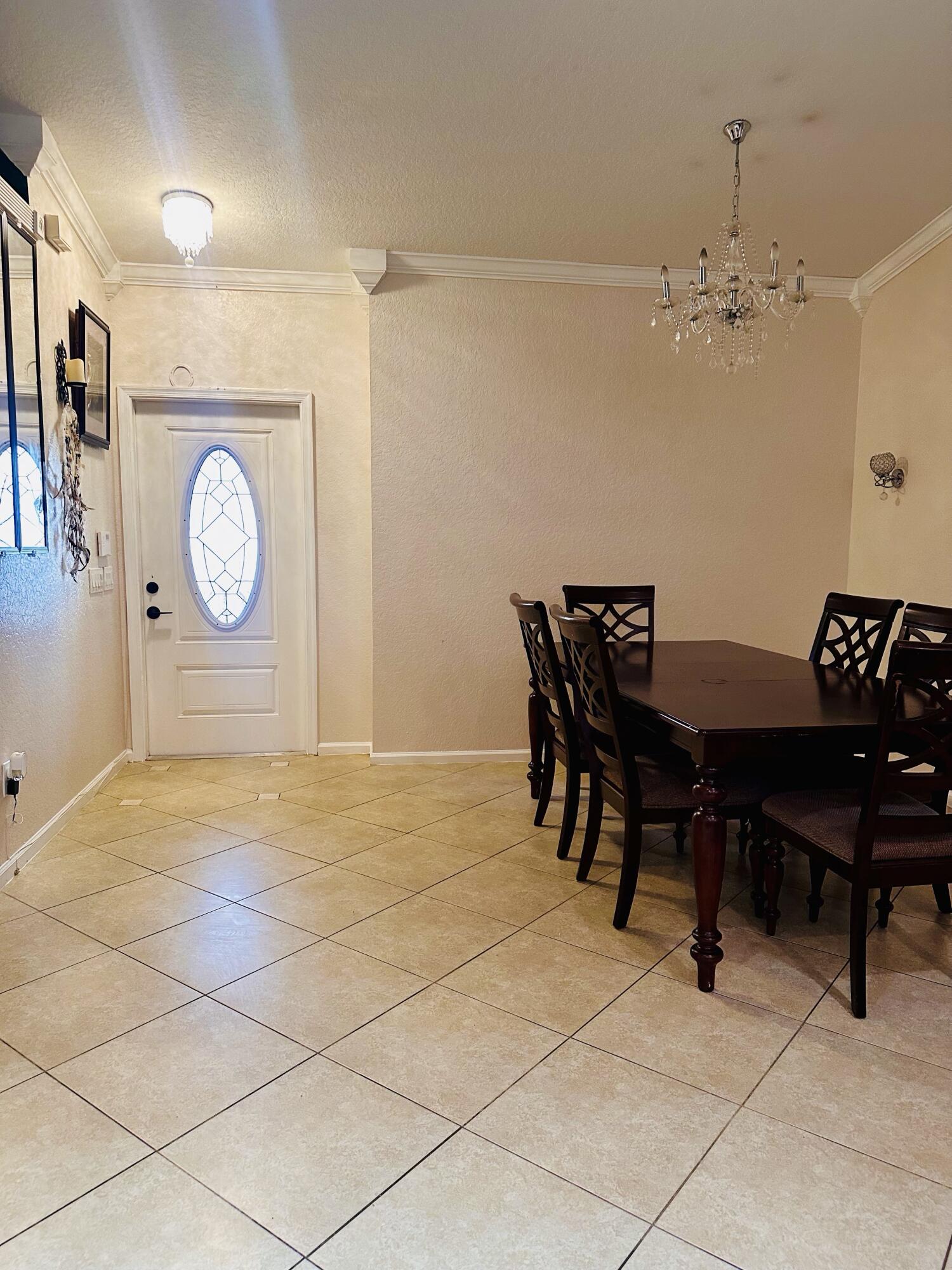 5200 Rising Comet Lane Greenacres, FL 33463 - Photo 7 of 50 a view of a dining room with furniture and chandelier
