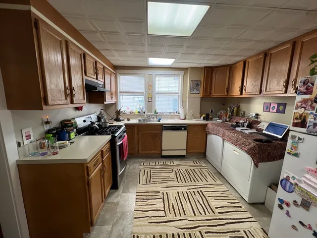 a kitchen with a sink stove top oven and cabinets