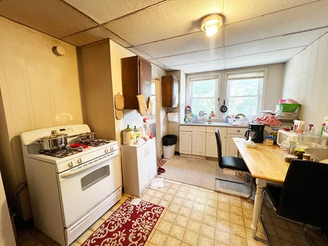 a kitchen with a stove a refrigerator and a dining table