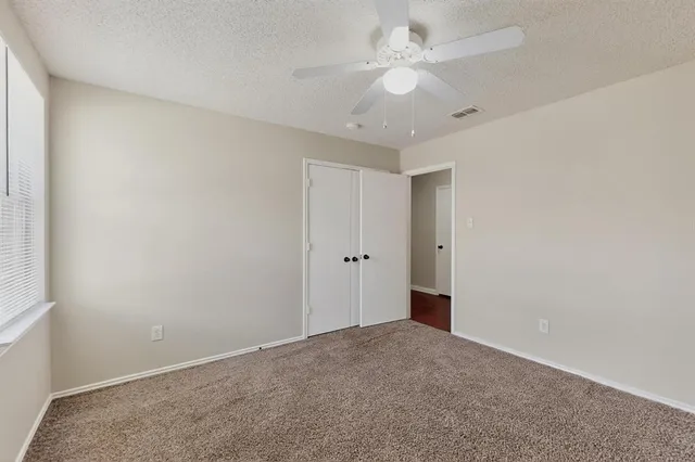a view of an empty room with a ceiling fan