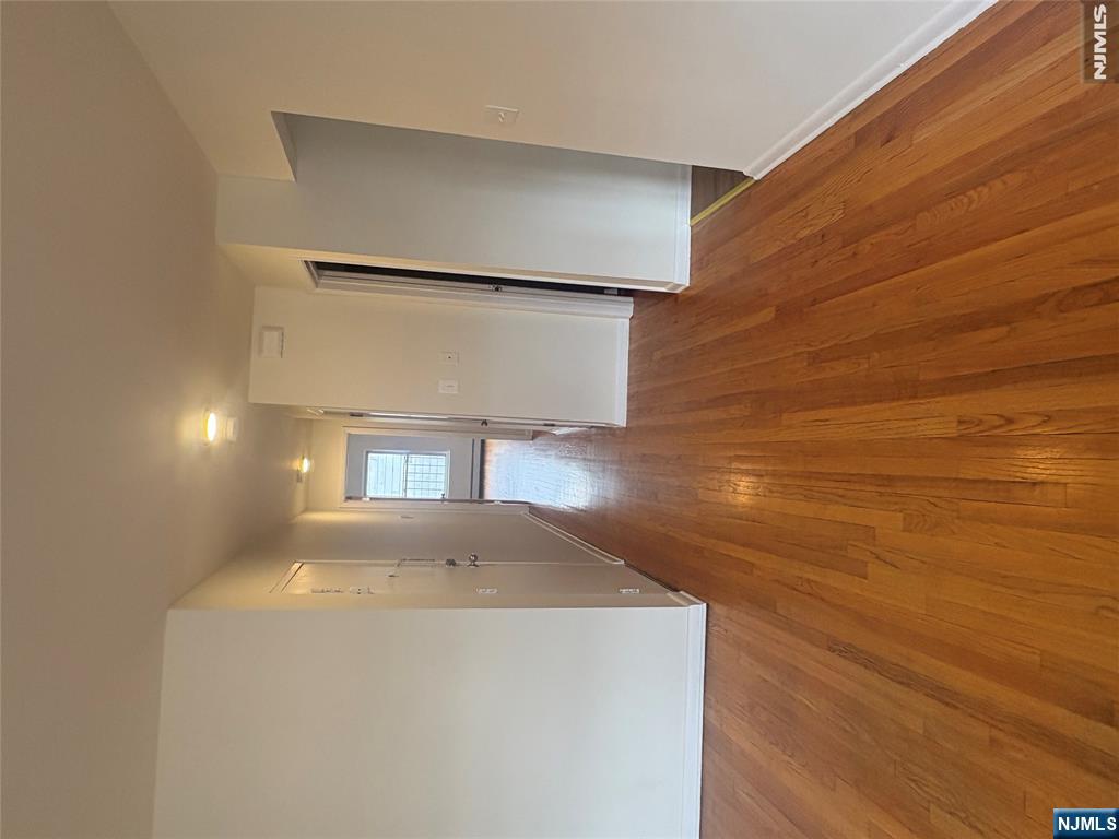399 Walker Street, Unit 1B Fairview, NJ 07022 - Photo 2 of 11 a view of hallway with wooden floor