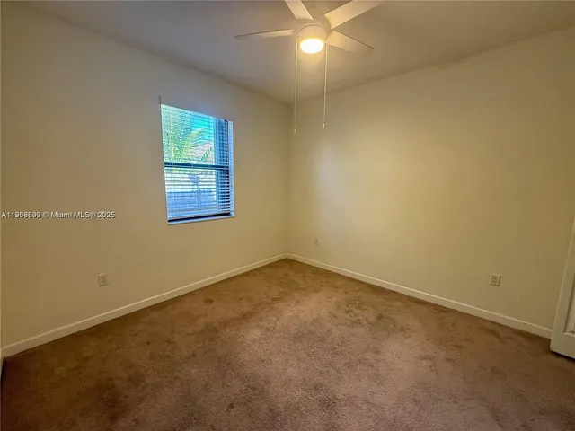 an empty room with closet and fan