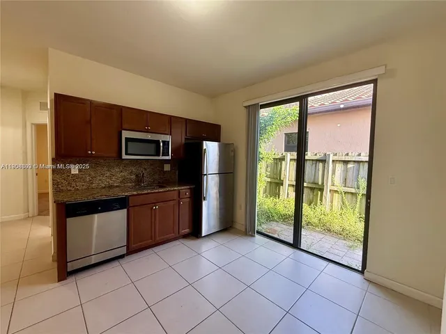 a kitchen with granite countertop a stove top oven microwave and cabinets