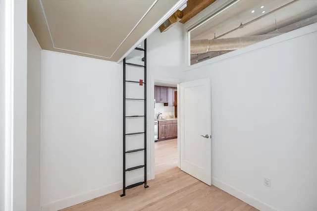 a view of a hallway with wooden floor and entryway