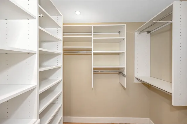 a view of walk in closet with empty racks