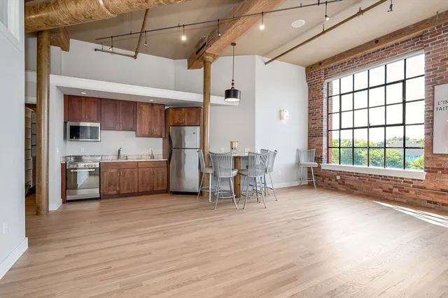 a view of a kitchen with a sink wooden cabinets and a window