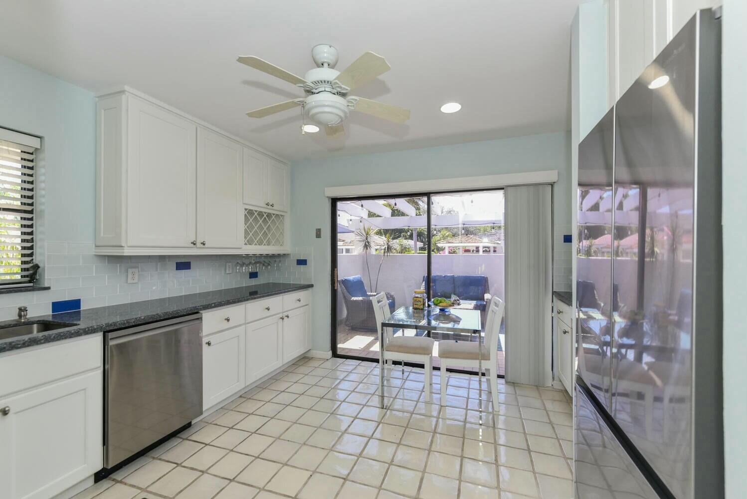 3736 Freshwater Drive Jupiter, FL 33477 - Photo 5 of 28 a open kitchen with granite countertop a sink and white cabinets