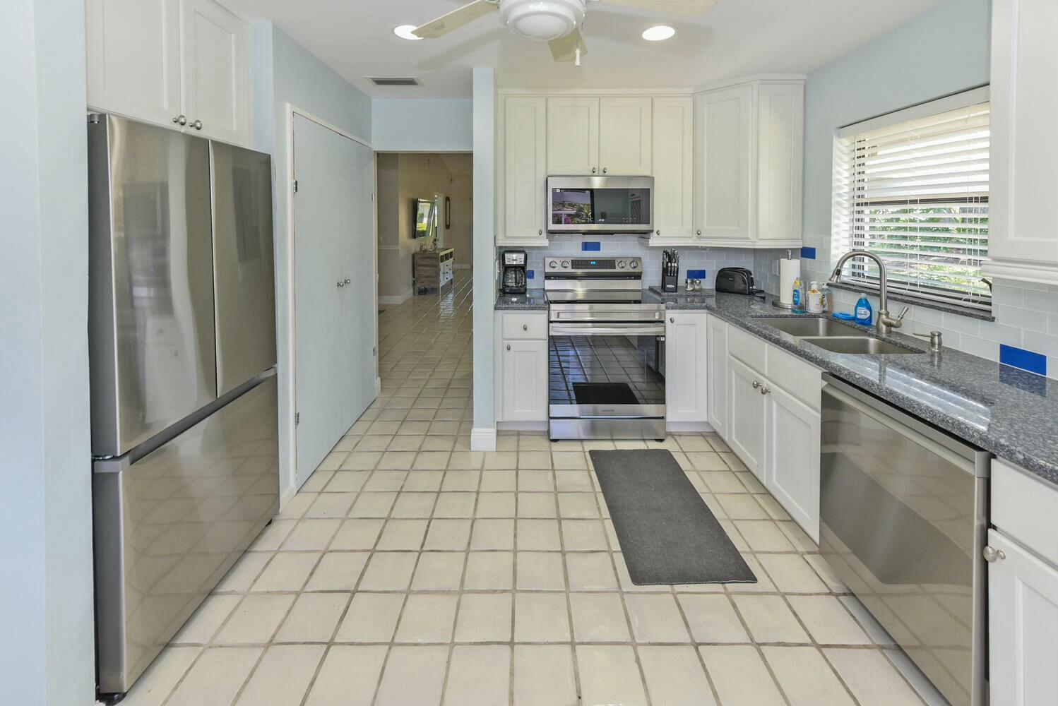 3736 Freshwater Drive Jupiter, FL 33477 - Photo 9 of 28 a kitchen with stainless steel appliances granite countertop a refrigerator sink and stove