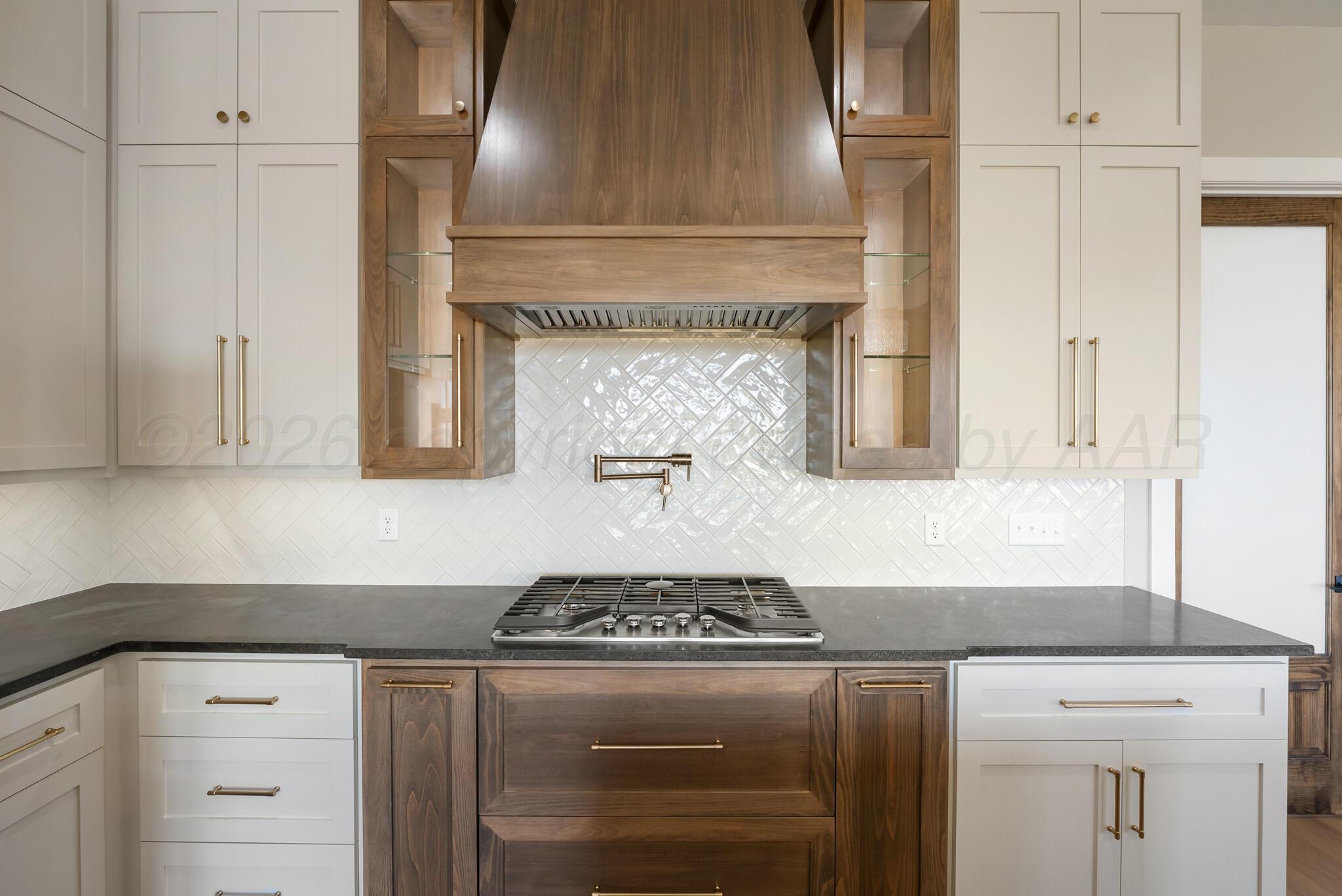 4201 Juniper Springs Road Amarillo, TX 79119 - Photo 8 of 27 a kitchen with a stove and white cabinets