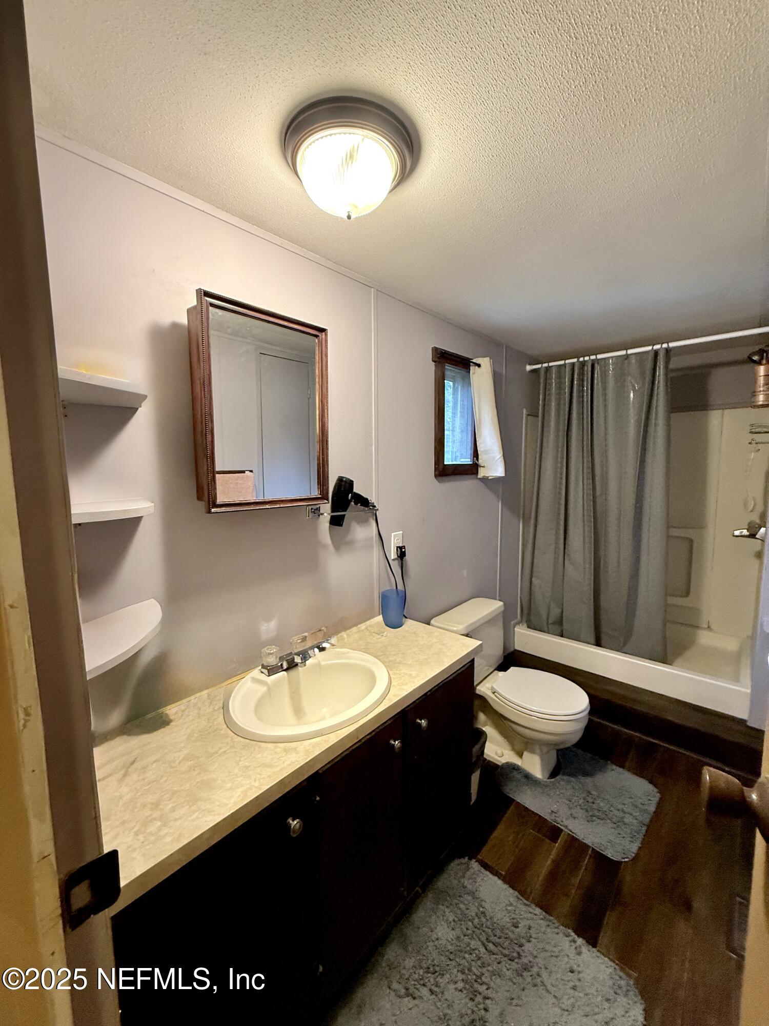 210 Lenore Avenue Interlachen, FL 32148 - Photo 28 of 43 a bathroom with a sink a toilet and a mirror