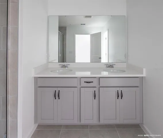 a bathroom with a sink vanity and mirror