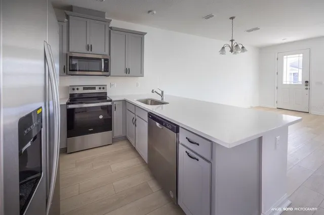 a kitchen with kitchen island a sink stove and refrigerator