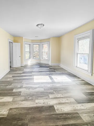 a view of empty room with window and fireplace