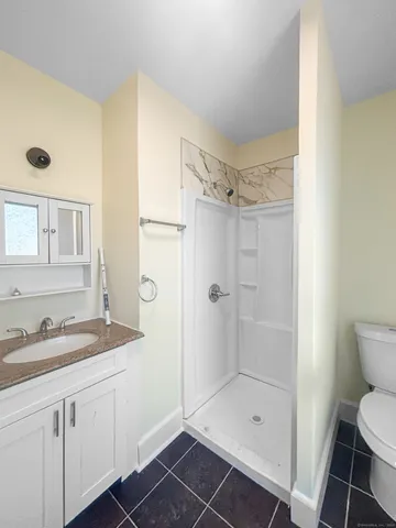 a bathroom with a sink a toilet and shower