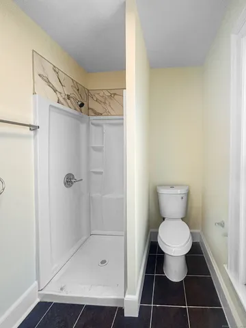 a bathroom with a toilet and a shower