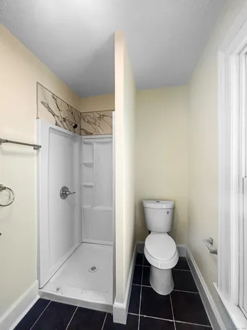 a bathroom with a toilet and a shower