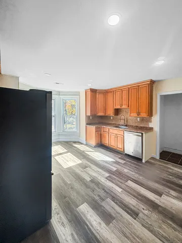 a kitchen with granite countertop a refrigerator and cabinets