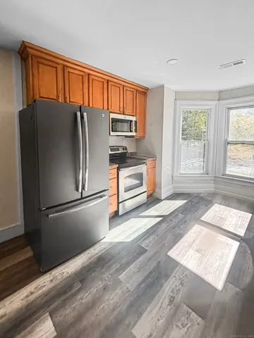 a kitchen with stainless steel appliances granite countertop a refrigerator and a sink