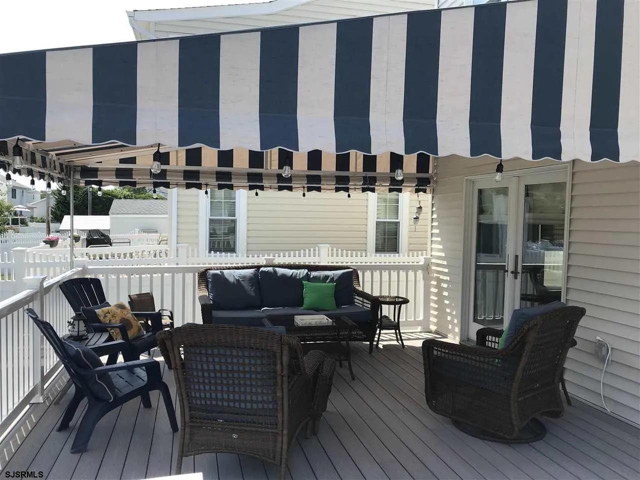 1328 Ouimet Road Brigantine, NJ 08203 - Photo 31 of 33 a view of a patio with couches and dining table with wooden floor