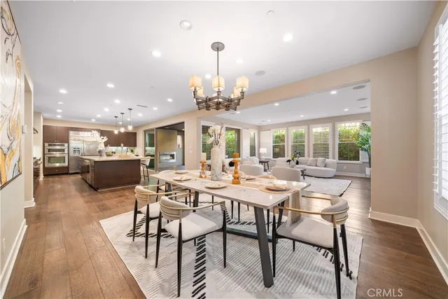 a kitchen with stainless steel appliances kitchen island granite countertop a table chairs sink and cabinets