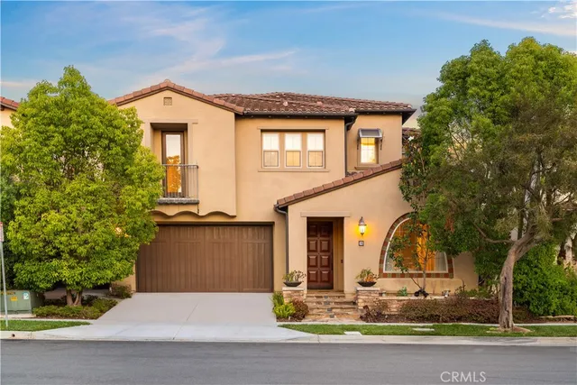 a living room with couches chandelier and a dining table with wooden floor