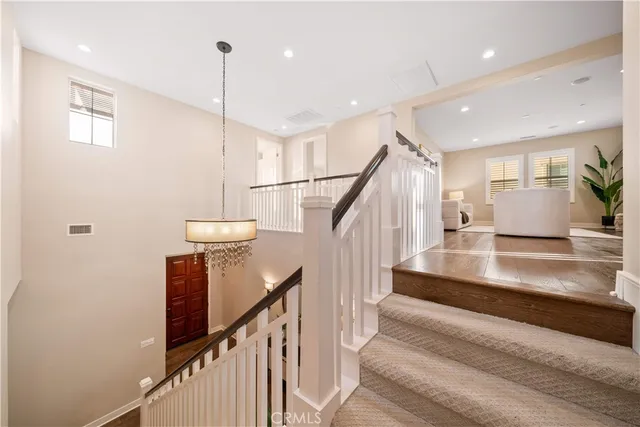 a view of a hallway with wooden floor and staircase