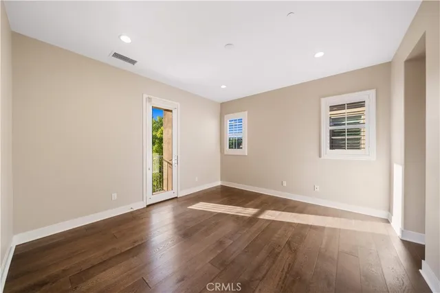 a view of empty room with wooden floor and windows