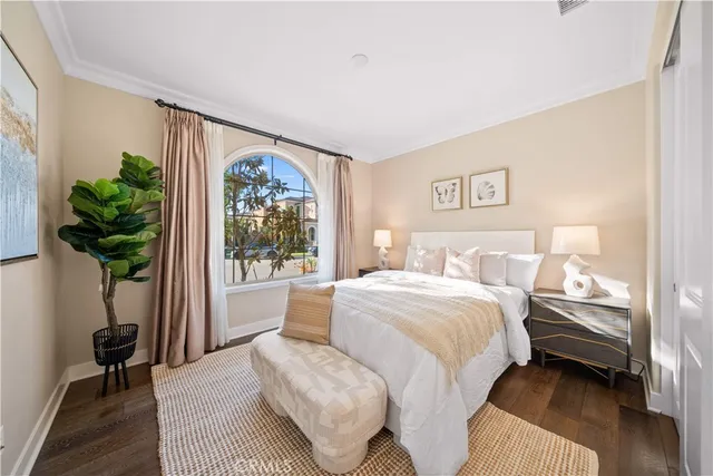 a bedroom with a large bed and a potted plant