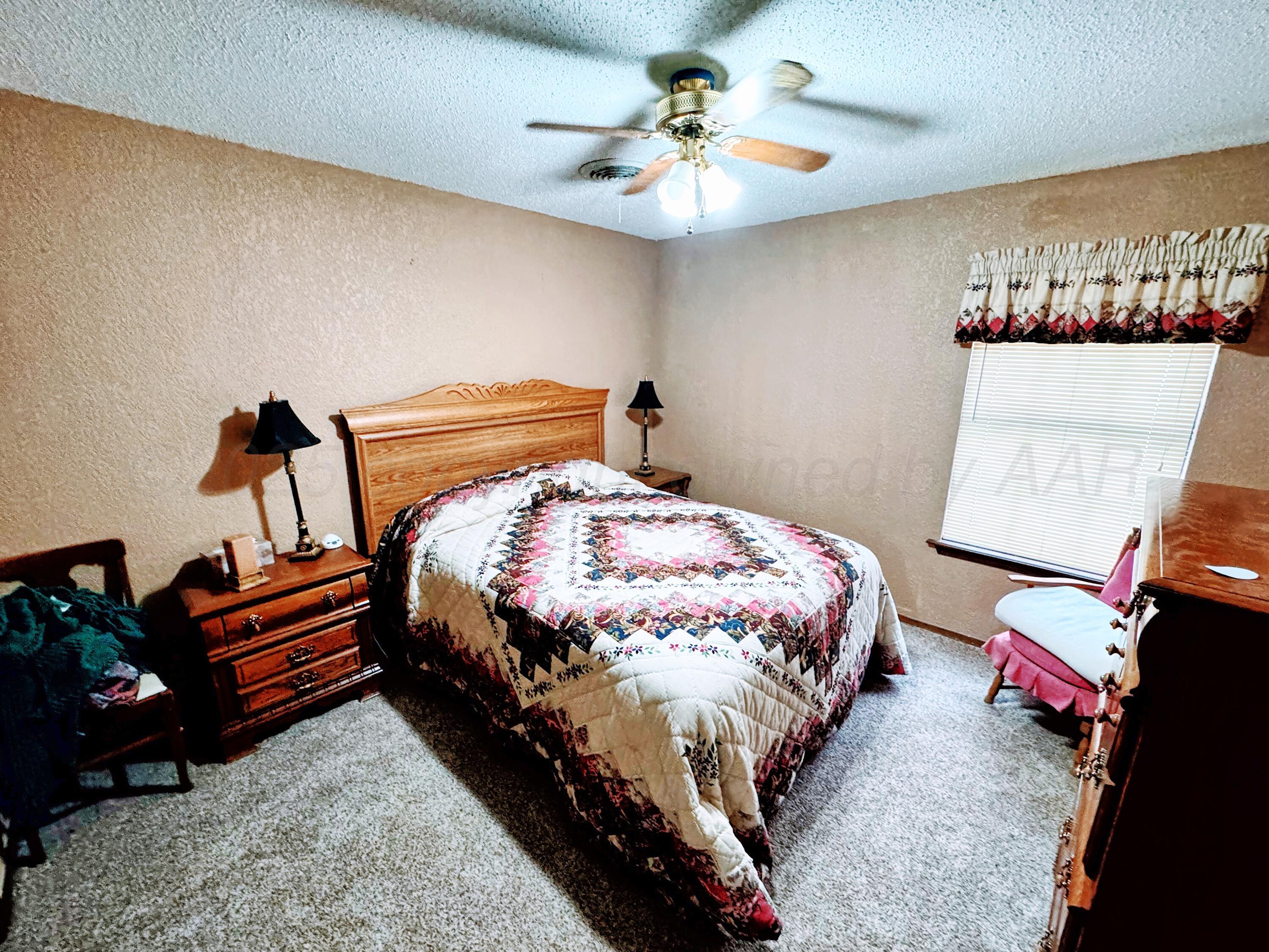 2310 South Elm Street Perryton, TX 79070 - Photo 11 of 24 a bedroom with a bed and a chandelier