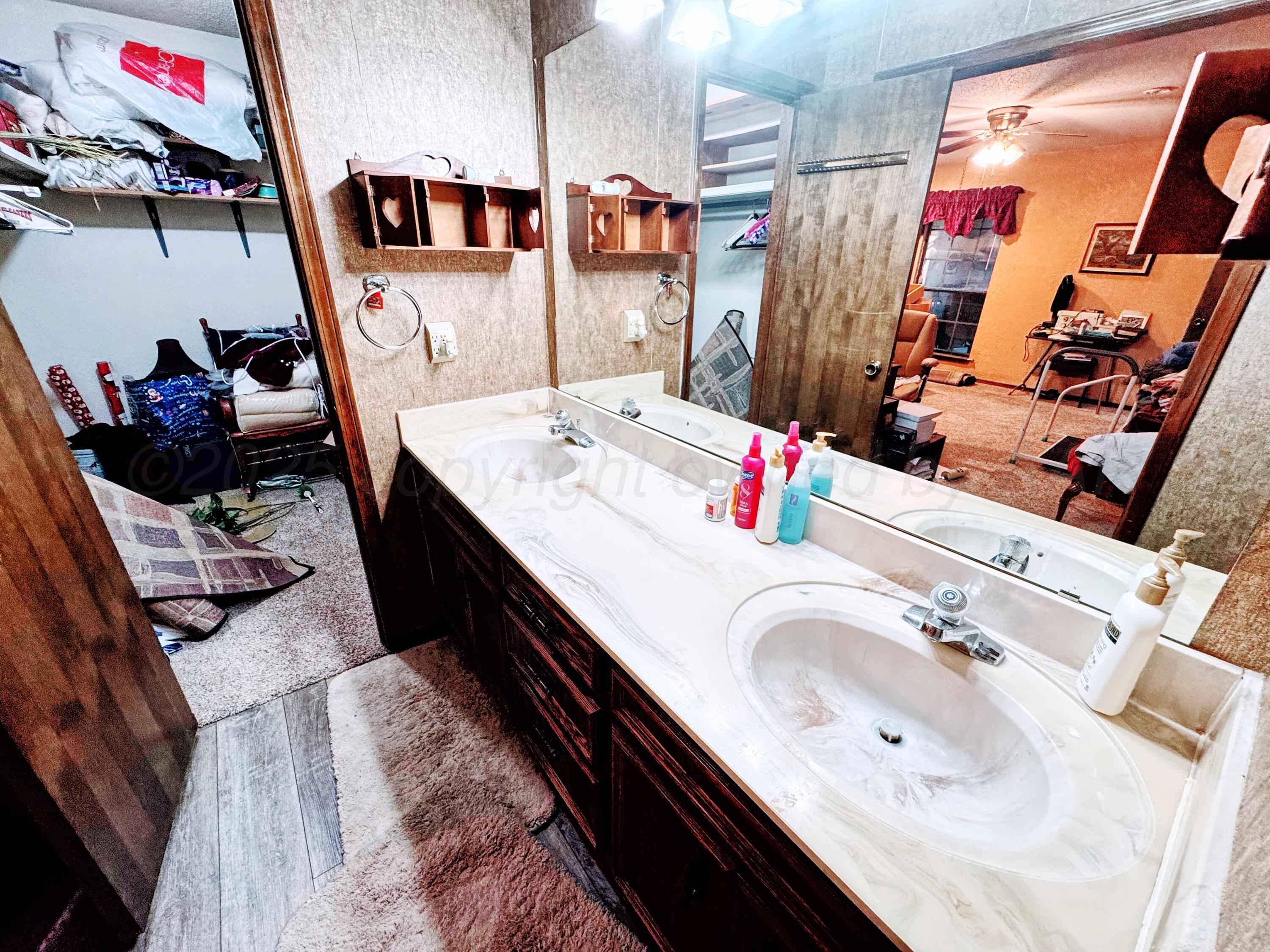 2310 South Elm Street Perryton, TX 79070 - Photo 14 of 24 a bathroom with double vanity sink and a mirror