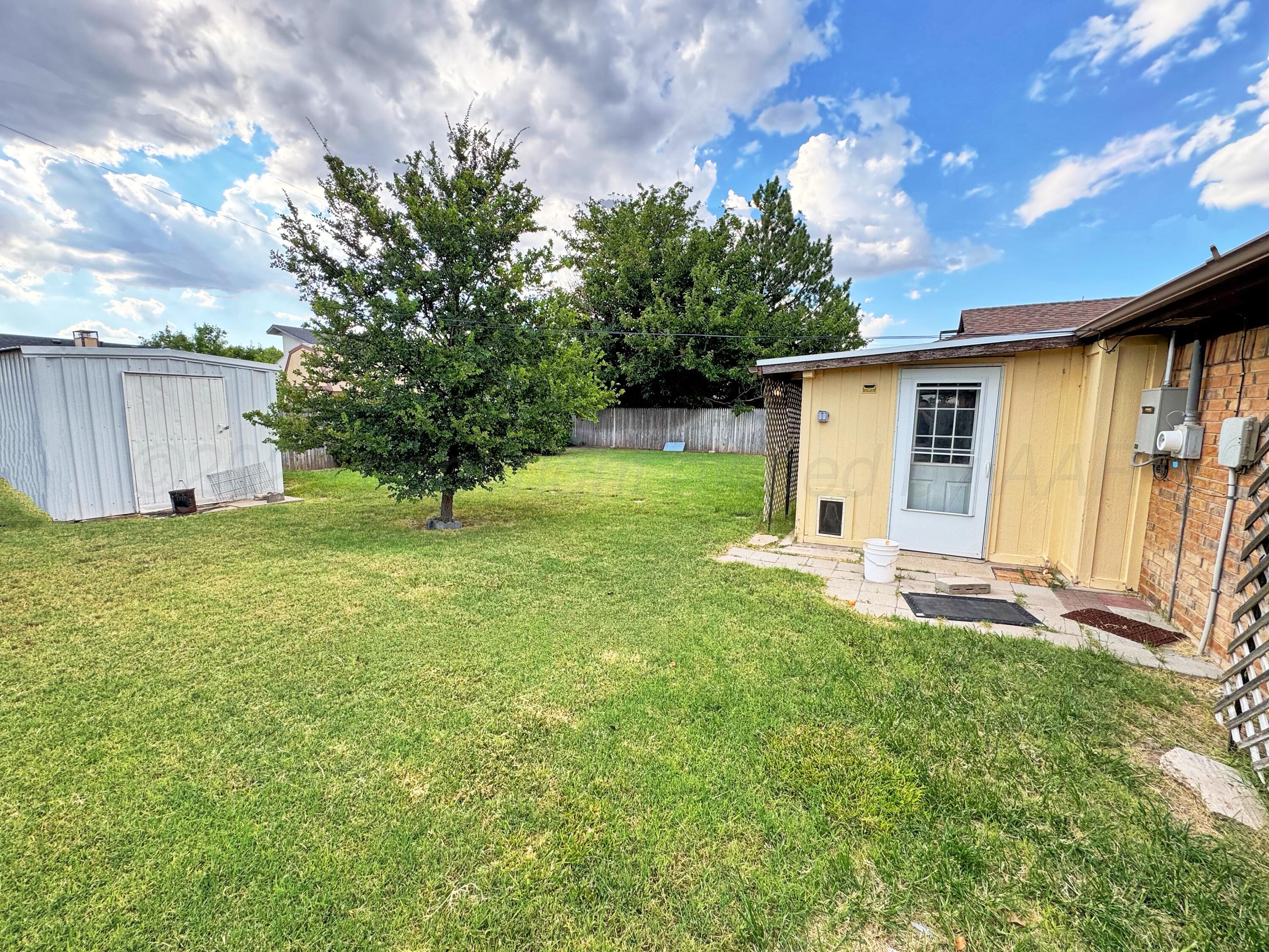2310 South Elm Street Perryton, TX 79070 - Photo 20 of 24 a view of a backyard with plants and large tree