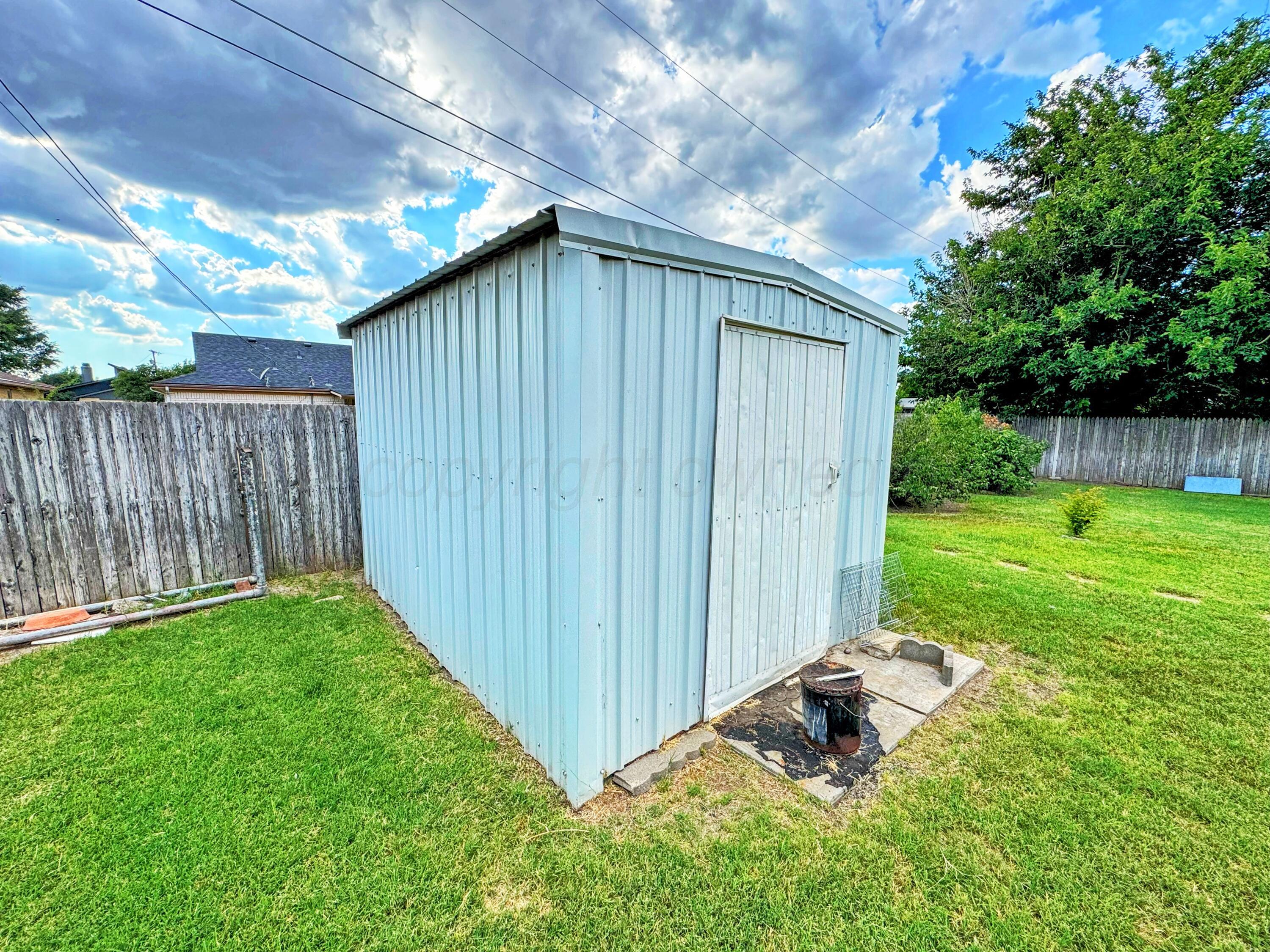2310 South Elm Street Perryton, TX 79070 - Photo 21 of 24 a backyard of a house with lawn chairs and wooden fence