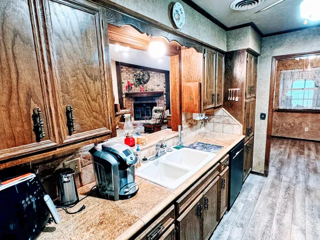 a kitchen with stainless steel appliances granite countertop a sink dishwasher and a stove with wooden floor