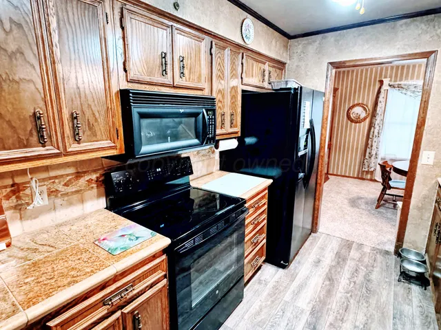 a kitchen with stainless steel appliances granite countertop a stove a refrigerator and a microwave