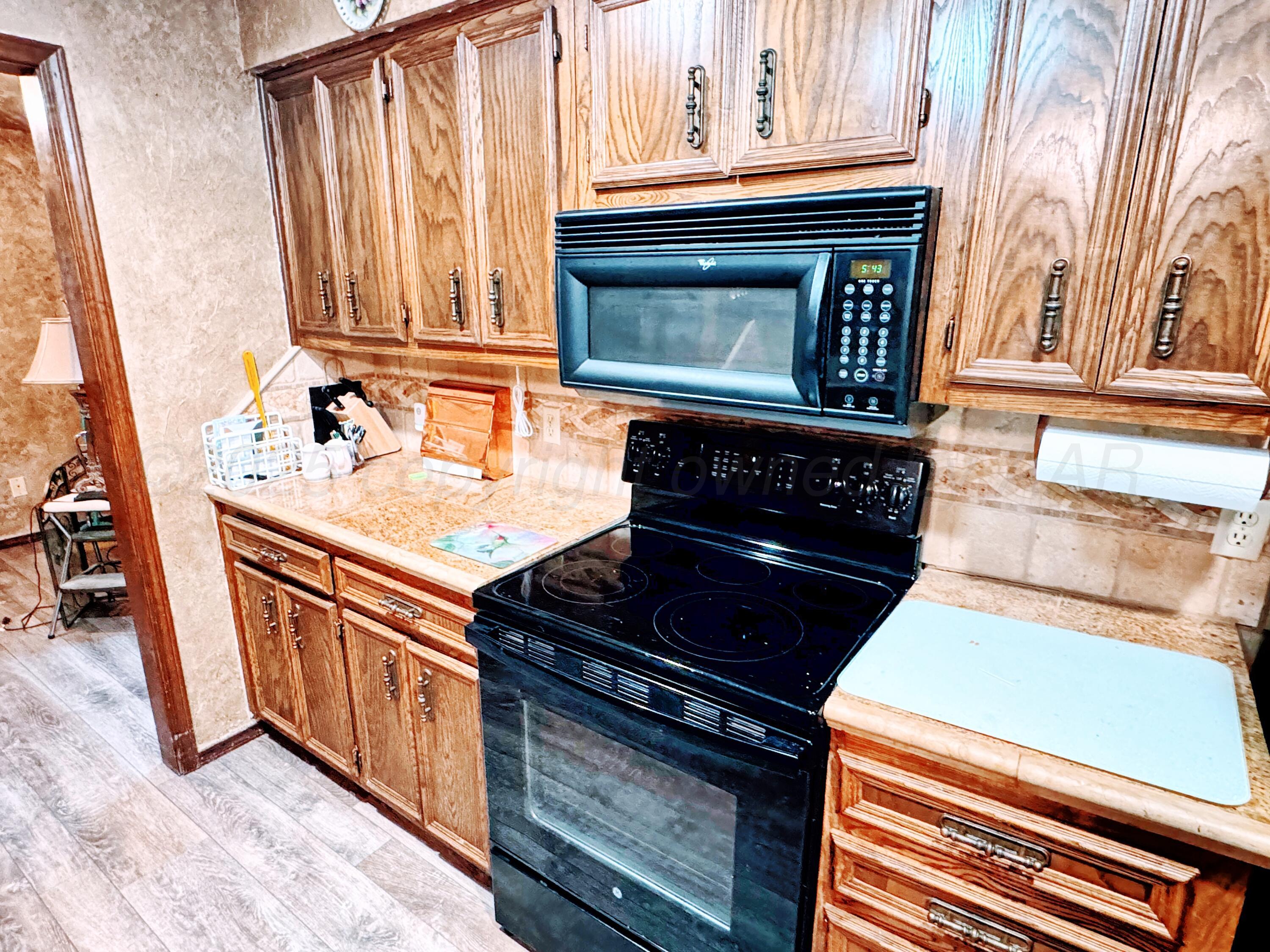 2310 South Elm Street Perryton, TX 79070 - Photo 6 of 24 a kitchen with granite countertop a stove and a sink