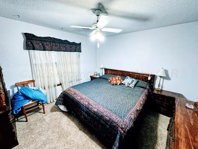 a bed sitting in a bedroom next to a window and a chandelier
