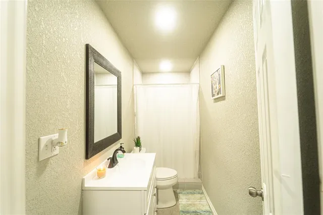 a bathroom with a sink mirror vanity and toilet