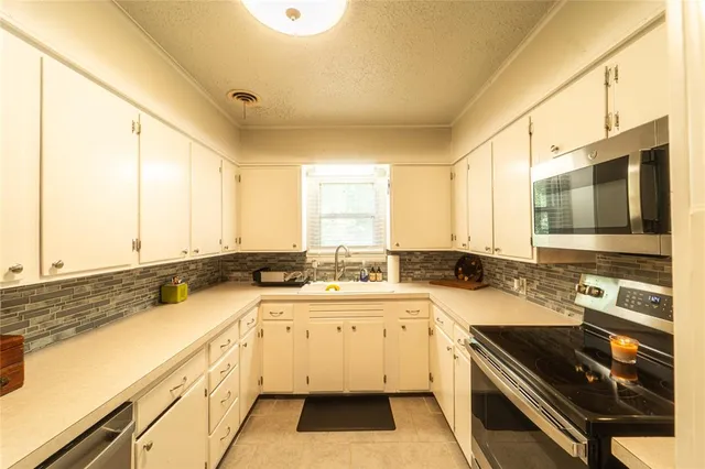 a large white kitchen with a large window