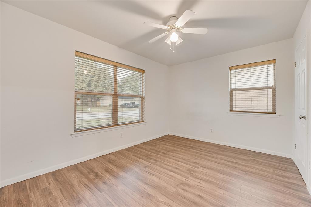 1017 Calcutta Street Hurst, TX 76053 - Photo 12 of 18 a view of an empty room with wooden floor and a window