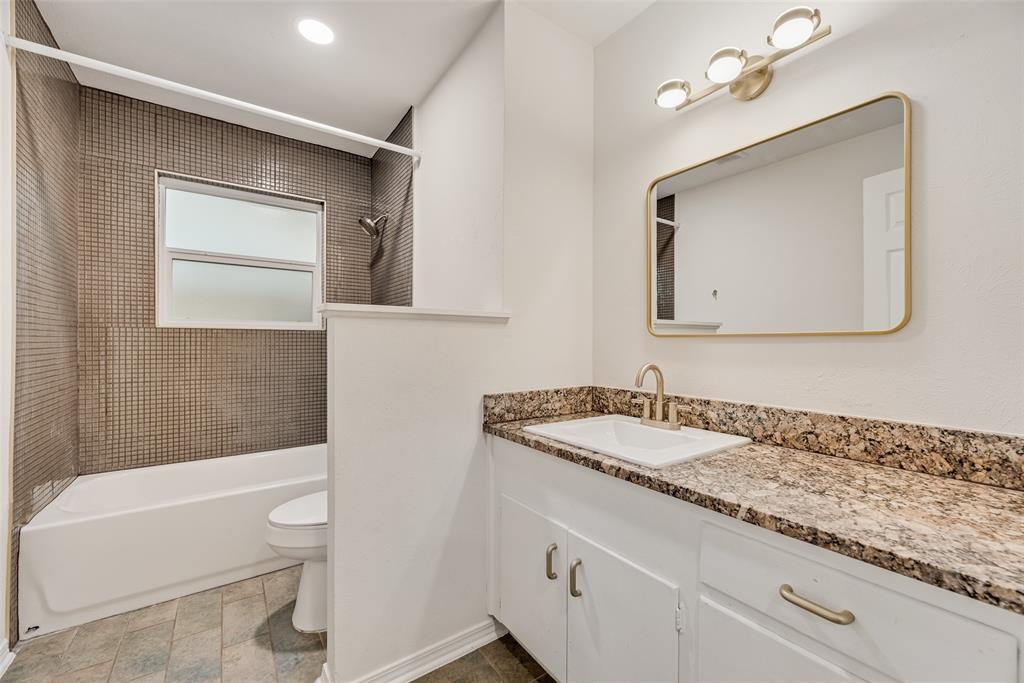 1017 Calcutta Street Hurst, TX 76053 - Photo 13 of 18 a bathroom with a granite countertop sink toilet and shower